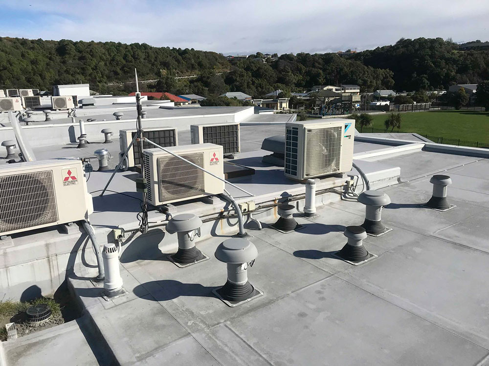 Flat commercial rooftop with waterproofing membrane installed and mechanical equipment